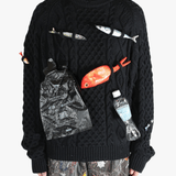 Black knitwear worn by a person, showing the knitwear's fit