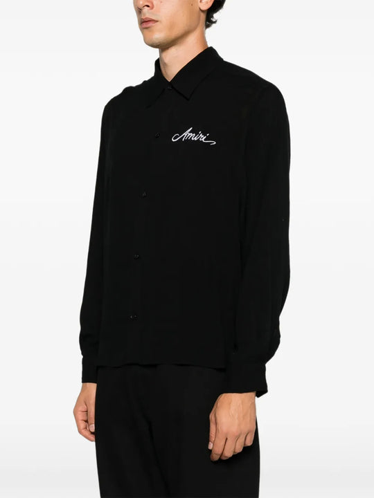 Black shirt worn by a person, showing the shirt fit