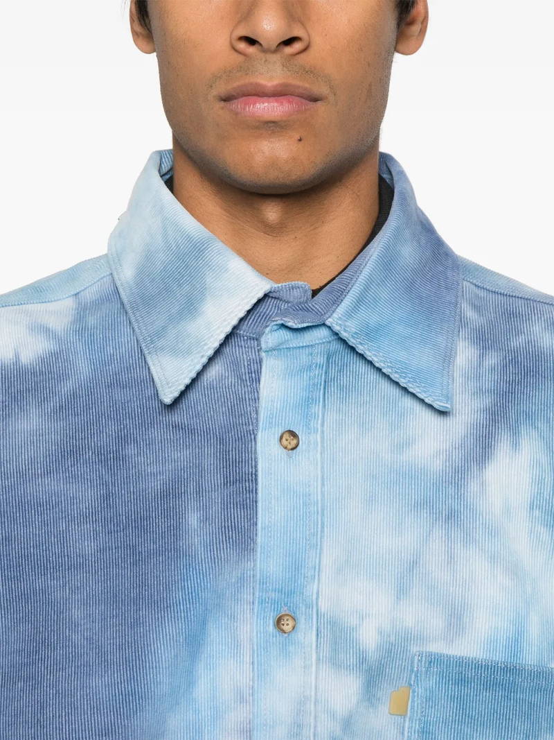 Close up of blue shirts, showing texture of the cotton fabric.