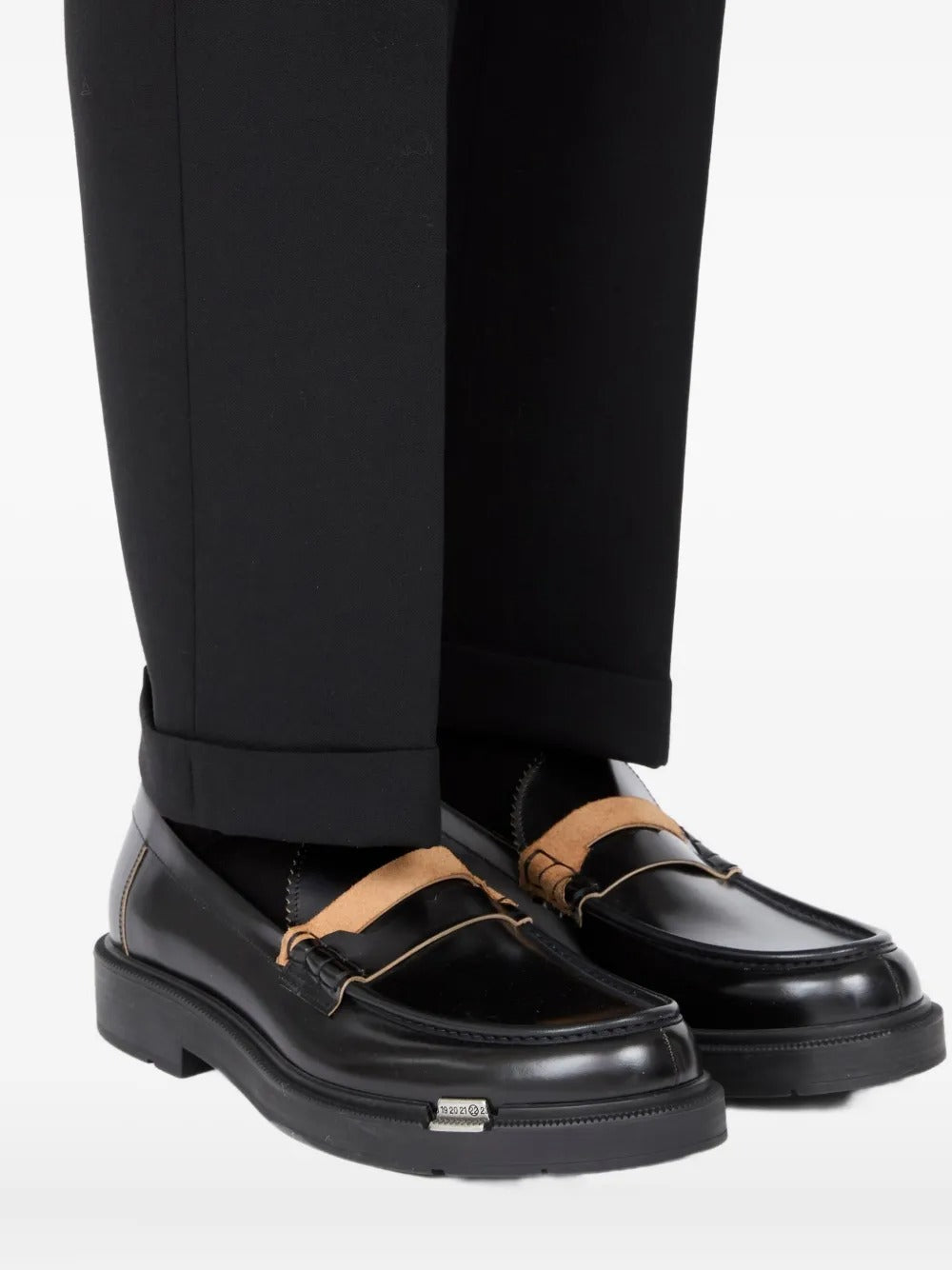 Black loafer worn by a person, showing the loafer's fit