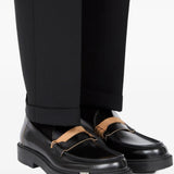 Black loafer worn by a person, showing the loafer's fit