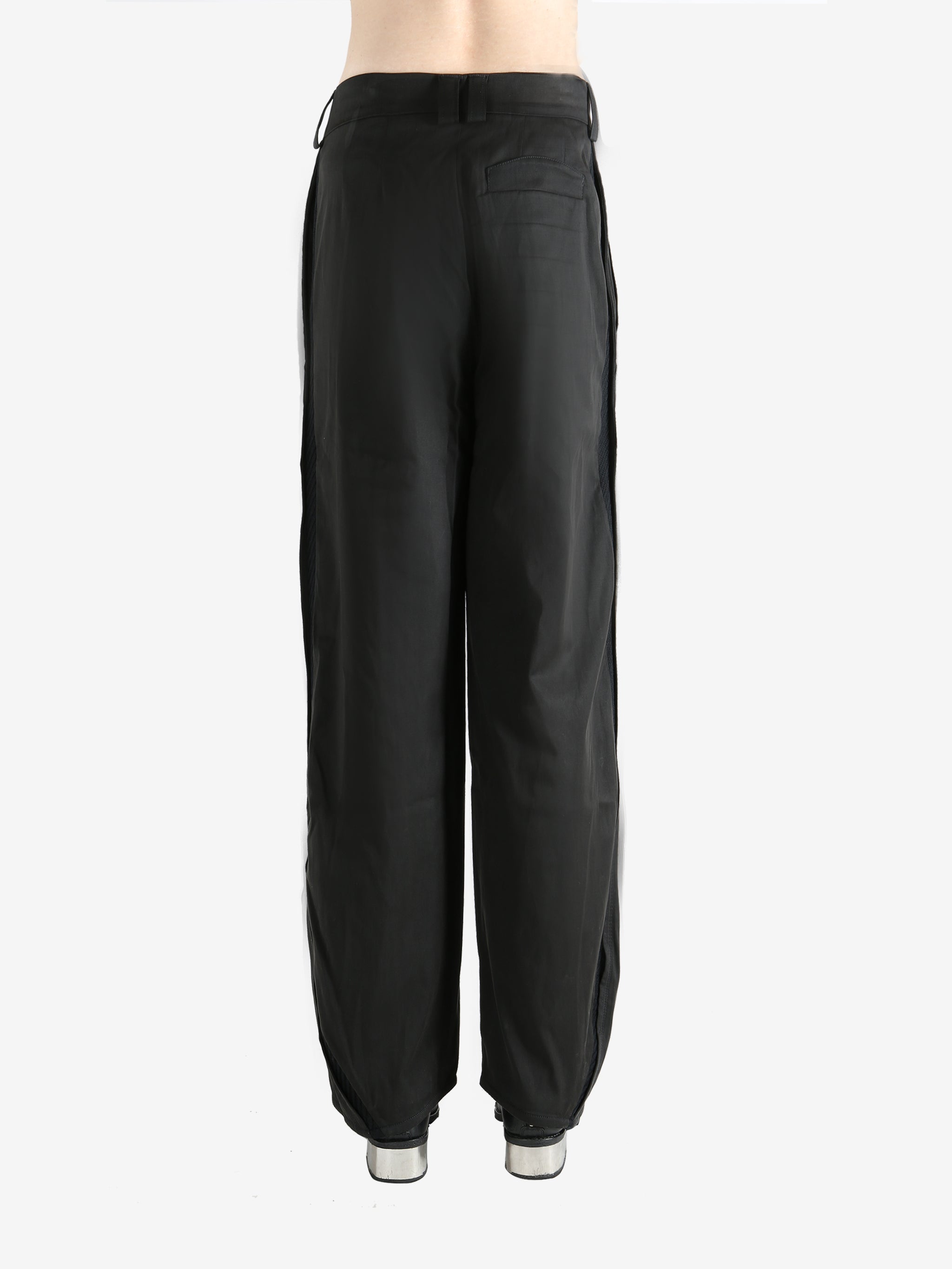 Black pants worn by a person, showing the pants' fit