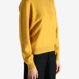 Yellow sweater worn by a person, showing the sweater's fit