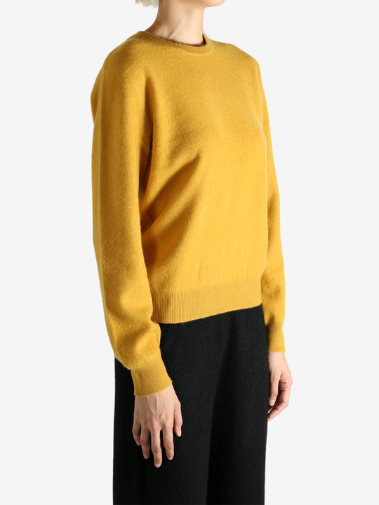 Yellow sweater worn by a person, showing the sweater's fit