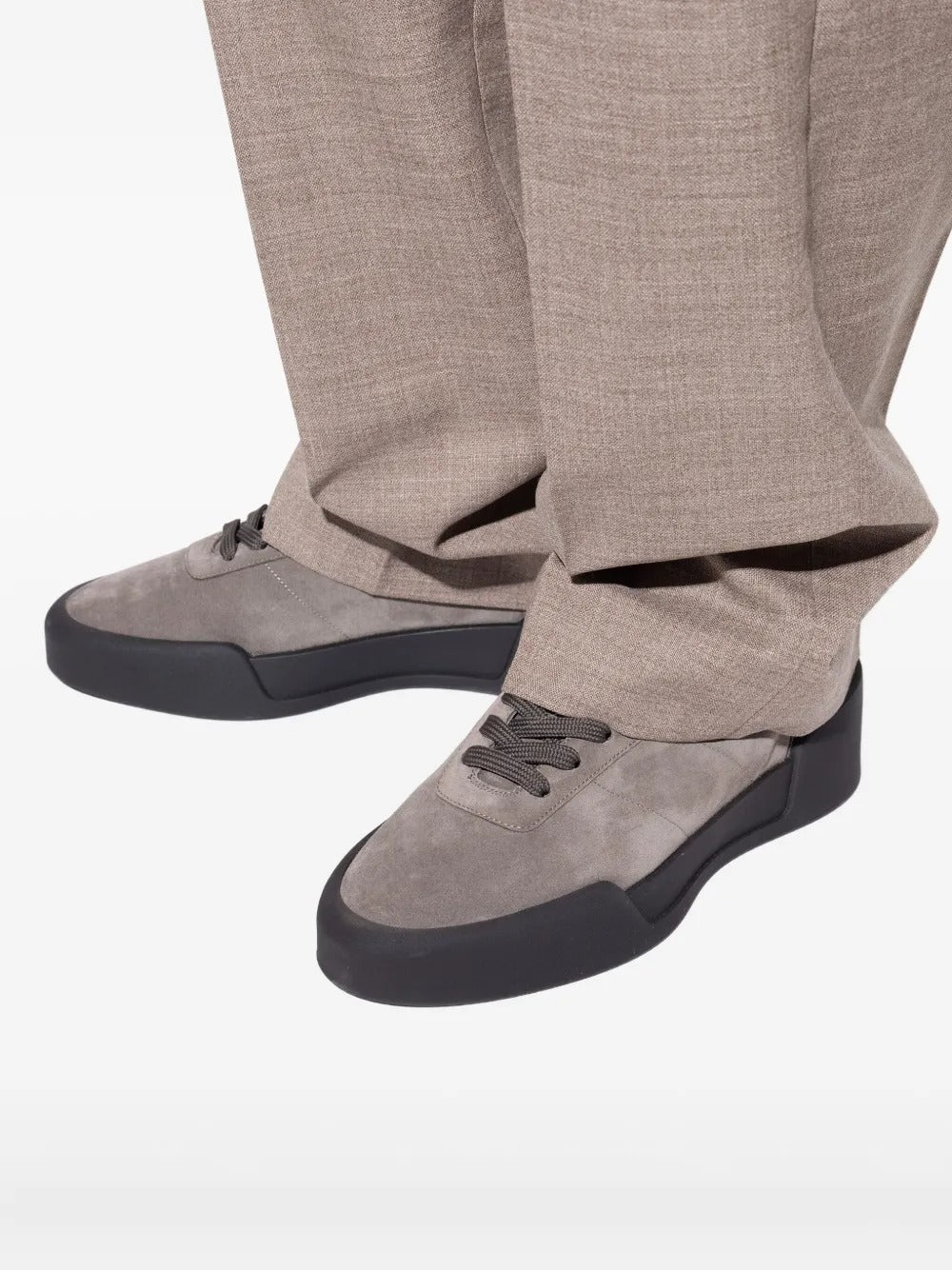 Grey sneakers worn by a person, showing the sneakers' fit