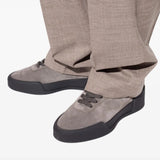 Grey sneakers worn by a person, showing the sneakers' fit