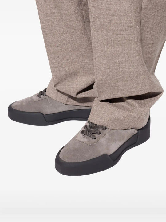 Grey sneakers worn by a person, showing the sneakers' fit