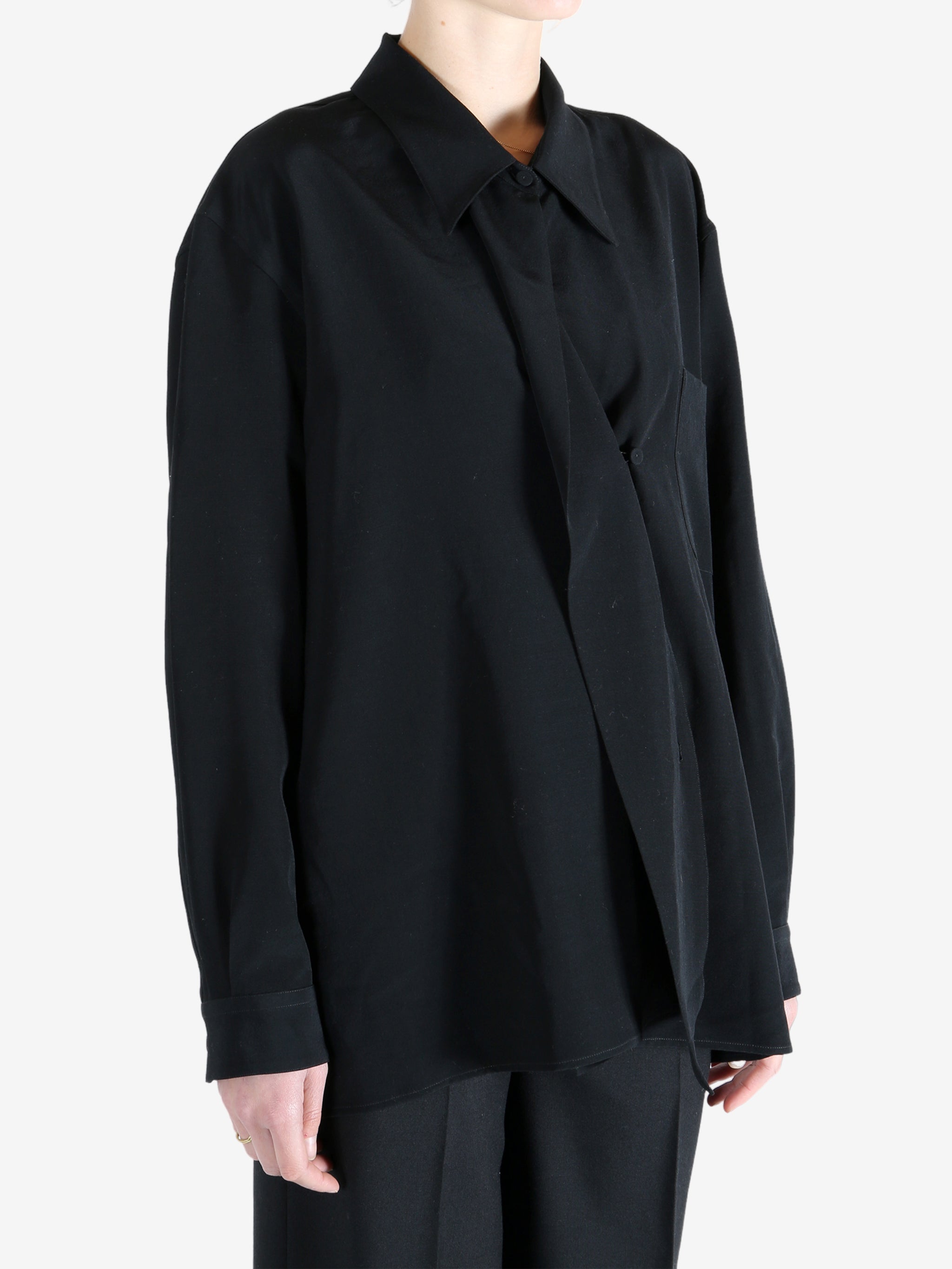 Black shirt worn by a person, showing the shirt's fit