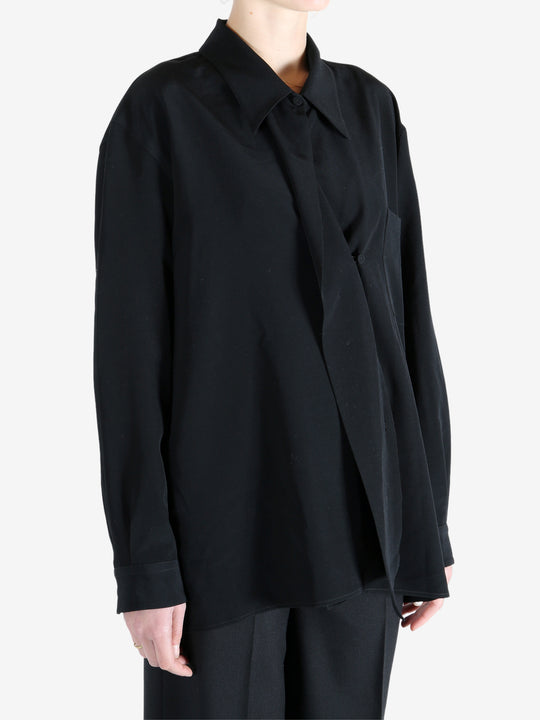 Black shirt worn by a person, showing the shirt's fit