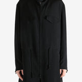 Black coat worn by a person, showing the coat fit