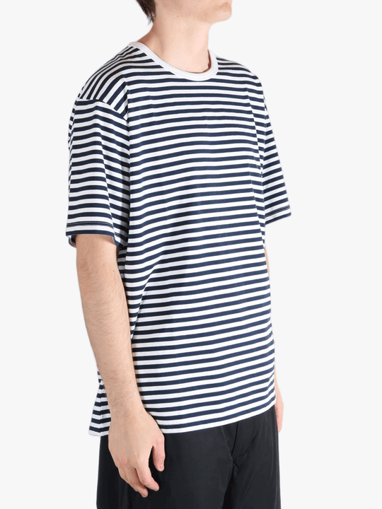 Black tee worn by a person, showing the tees fit