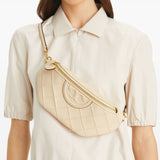 Tan bag carried by a person, showing the bag’s fit