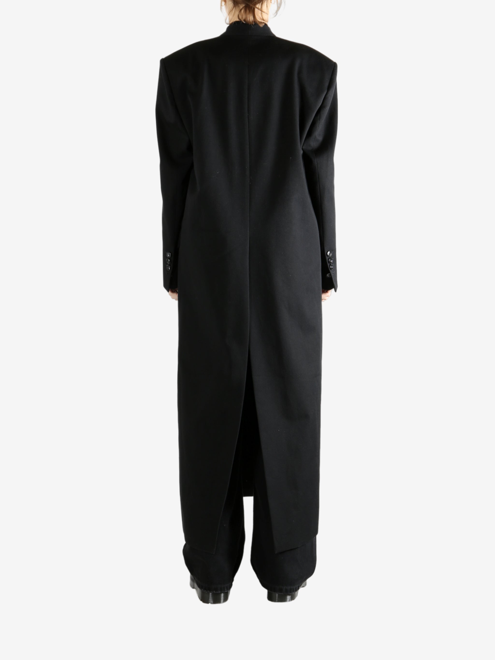 Black coats worn by a person, showing the coats fit