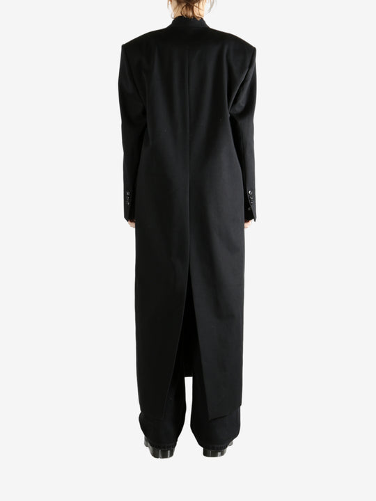 Black coats worn by a person, showing the coats fit