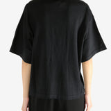 Black t-shirt worn by a person, showing the shirt's fit