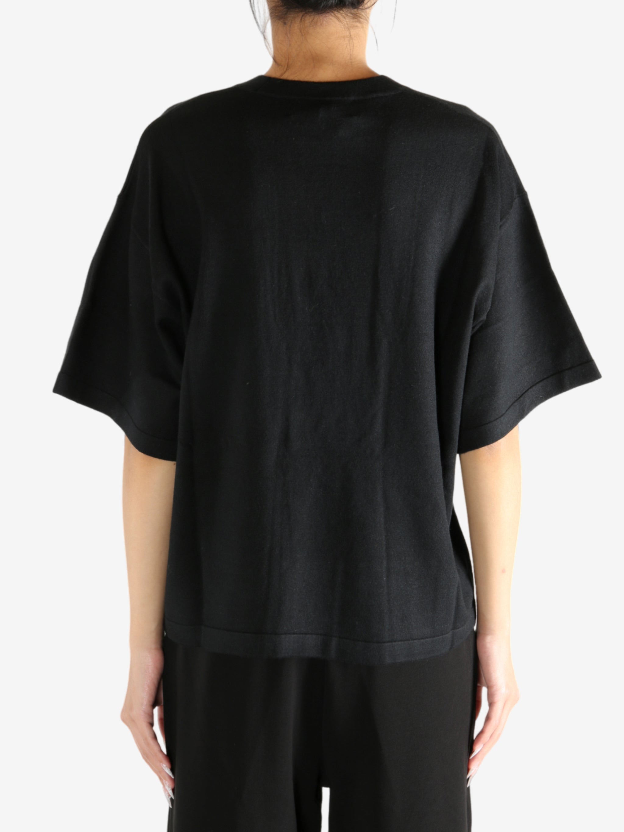 Black t-shirt worn by a person, showing the shirt's fit