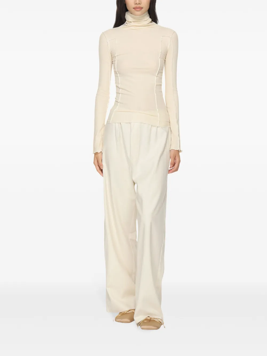 White top worn by a person, showing the top's fit