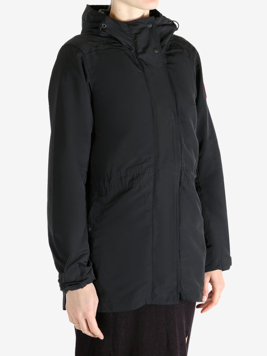 Black coat worn by a person, showing the coat fit