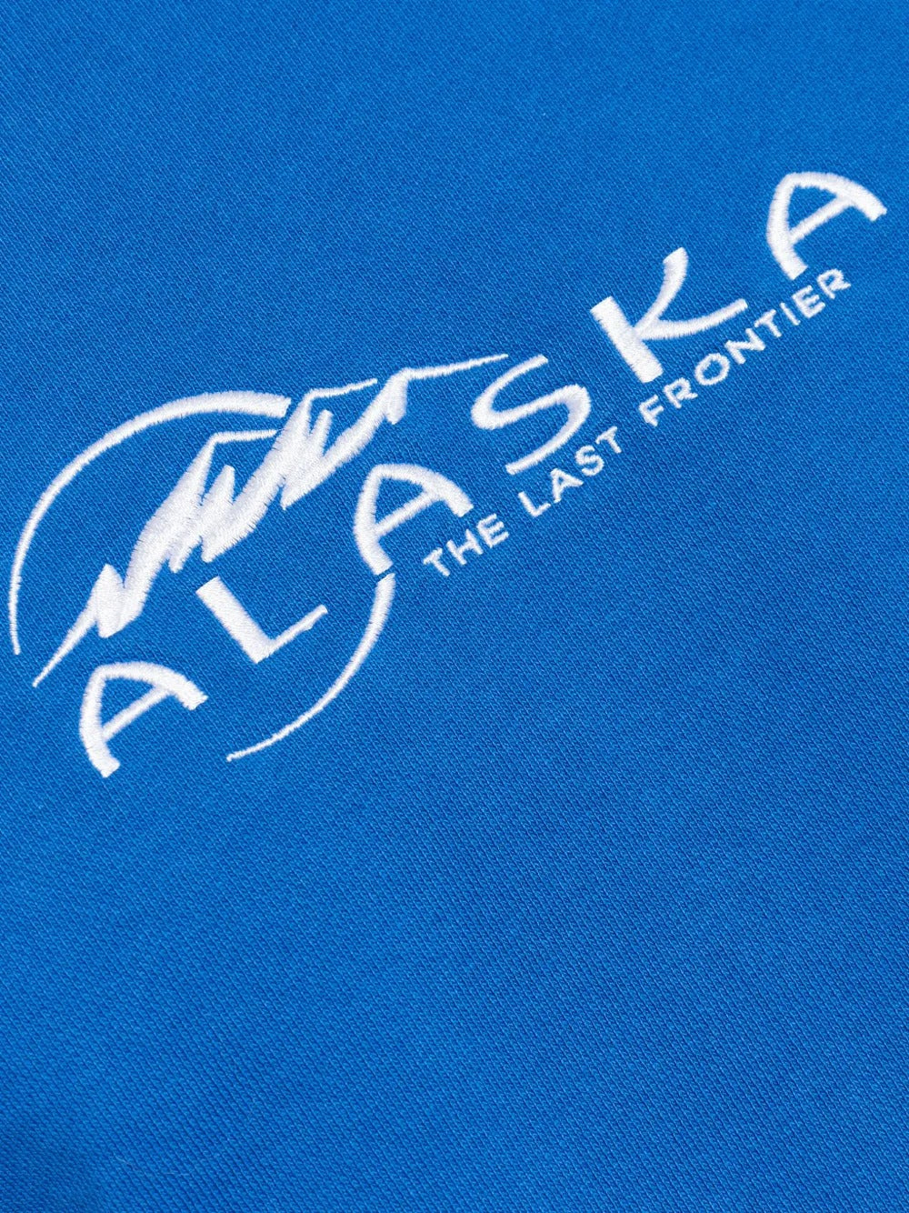 Close up of blue sweatshirt, showing texture of the  fabric