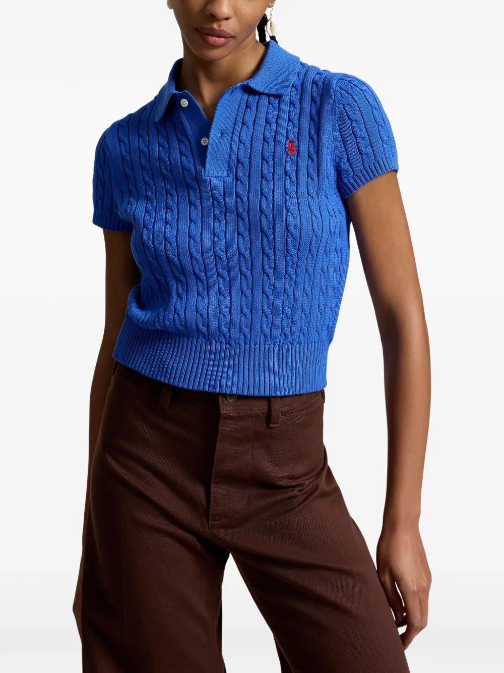 Blue knitted polo shirt worn by a person, showing the shirt's fit
