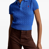 Blue knitted polo shirt worn by a person, showing the shirt's fit