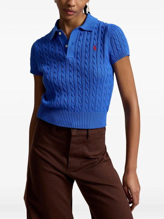 Blue knitted polo shirt worn by a person, showing the shirt's fit