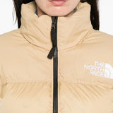 Close up of tan jackets, showing texture of the nylon and recycled down and recycled feather fabric