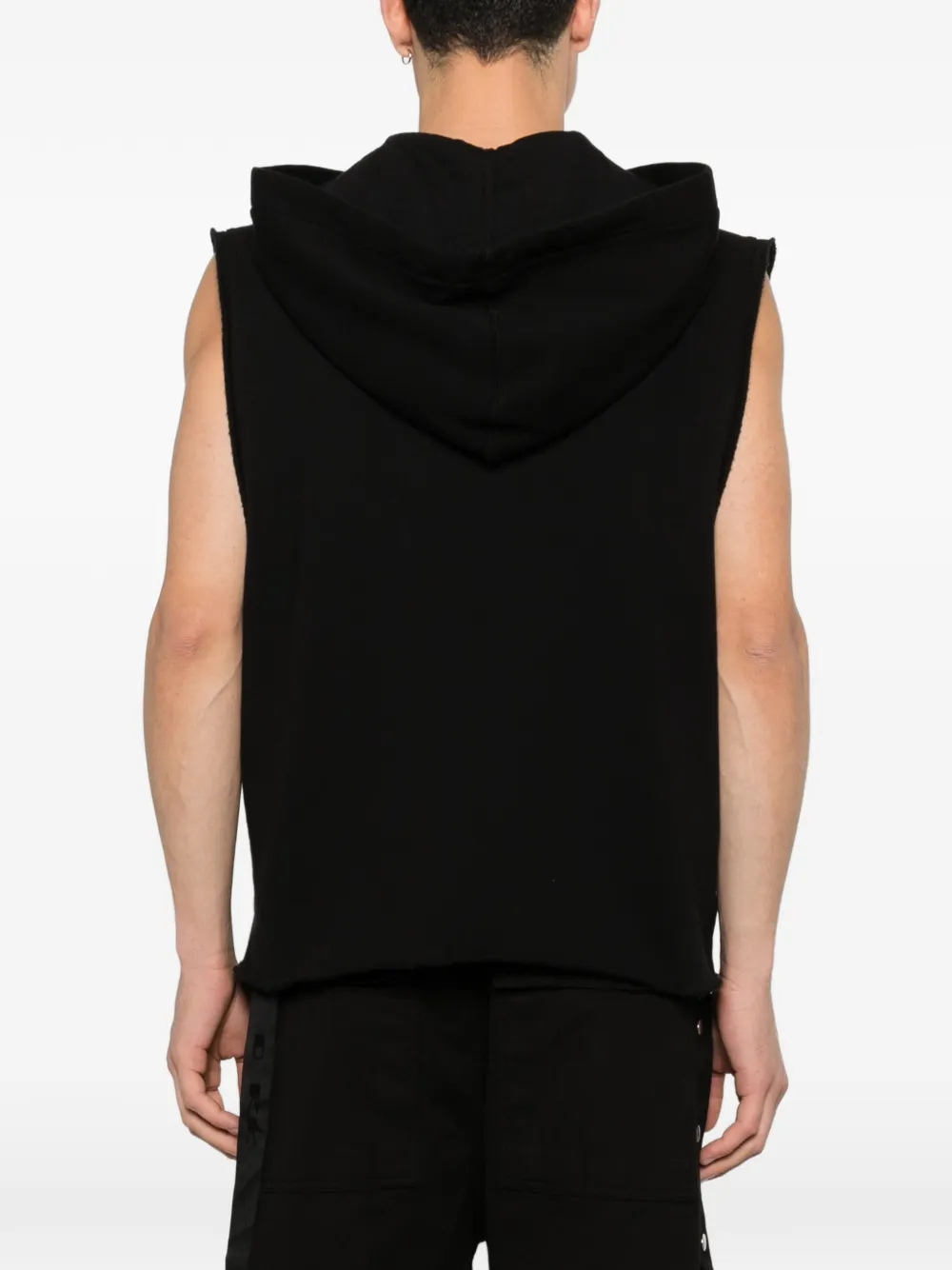 Black sleeveless hoodie worn by a person, showing the shirt's fit