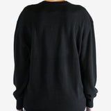 Black knitwear, worn by a person, showing the knitwear's fit