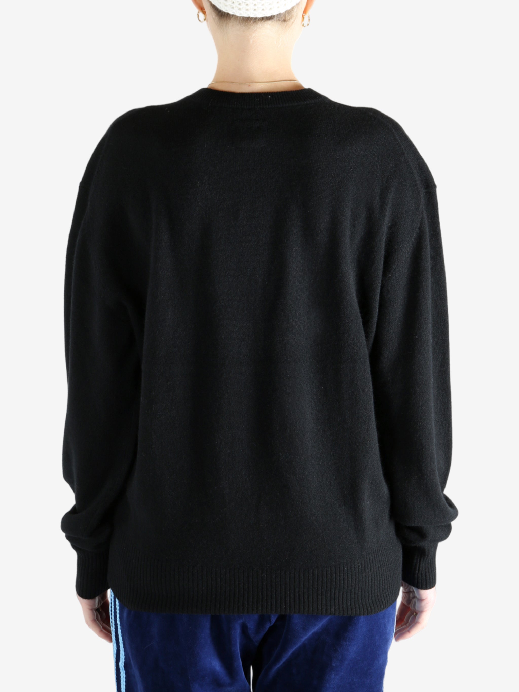 Black knitwear, worn by a person, showing the knitwear's fit