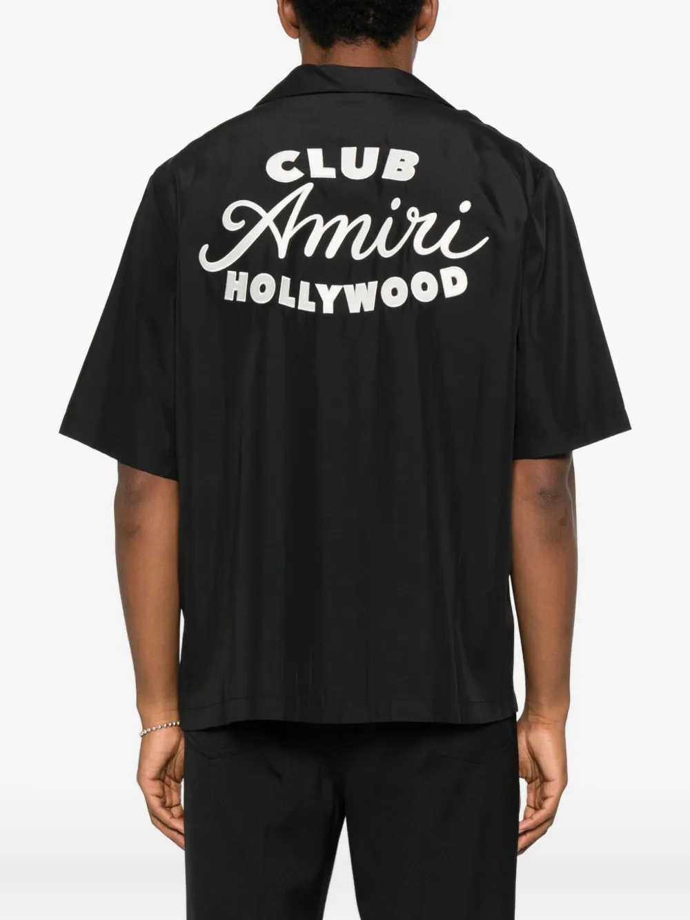 Black shirt worn by a person, showing the shirt's fit