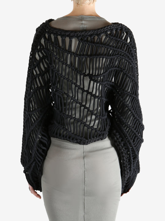 Black knitwear worn by a person, showing the knitwear fit