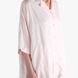 Light pink button-up shirt worn by a person,showing the shirt's fit