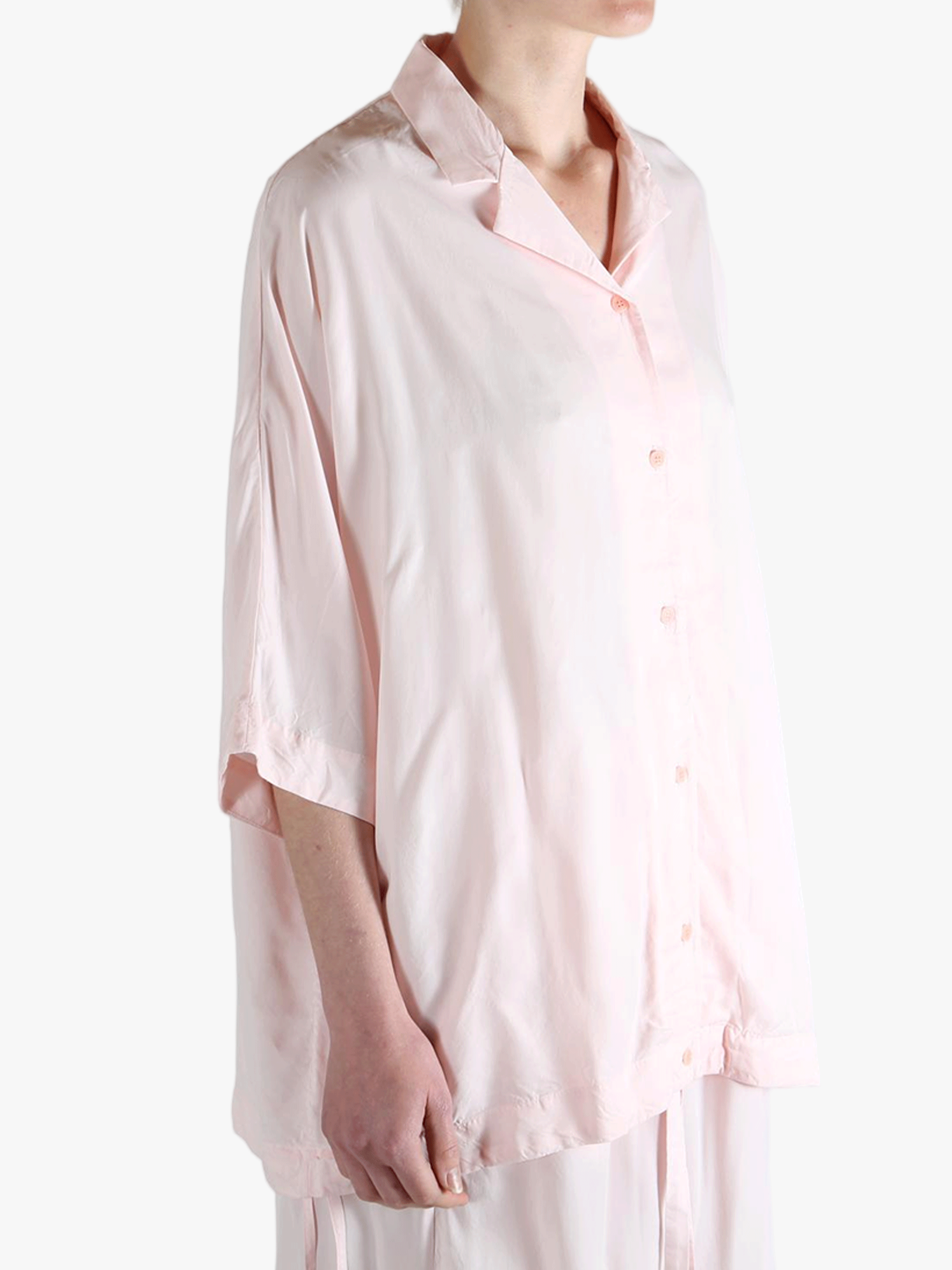 Light pink button-up shirt worn by a person,showing the shirt's fit