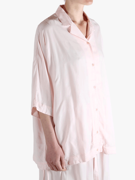 Light pink button-up shirt worn by a person,showing the shirt's fit