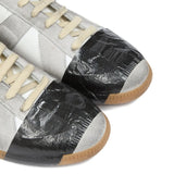 Close up of white sneakers, showing texture of the leather and rubber and polyethylene and cotton fabric