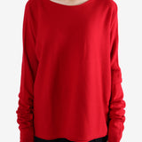 Red knitwear worn by a person, showing the knitwear's fit