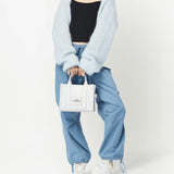 White bag carried by a person, showing the bag's fit