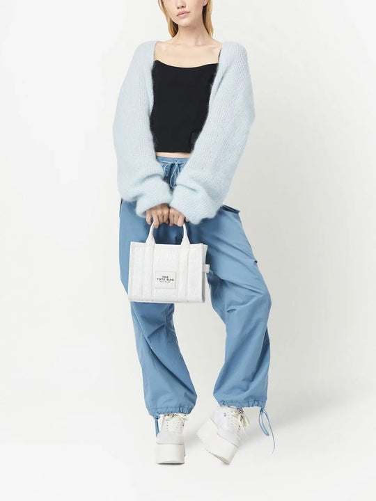 White bag carried by a person, showing the bag's fit