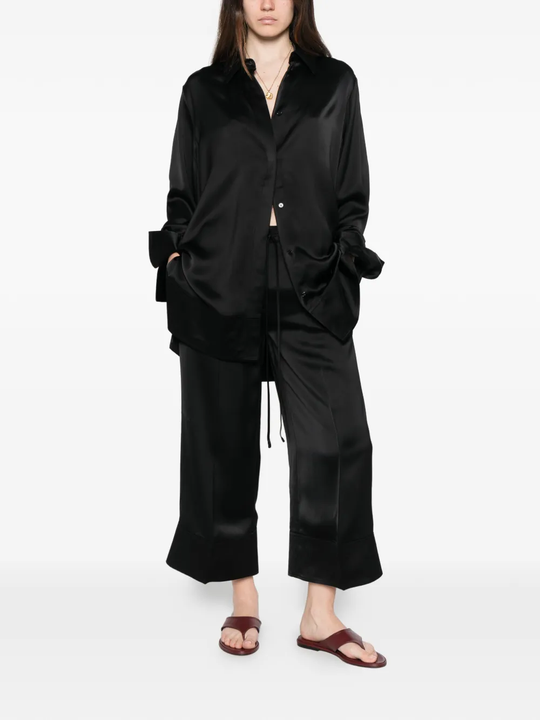 Black pants worn by a person, showing the pants' fit