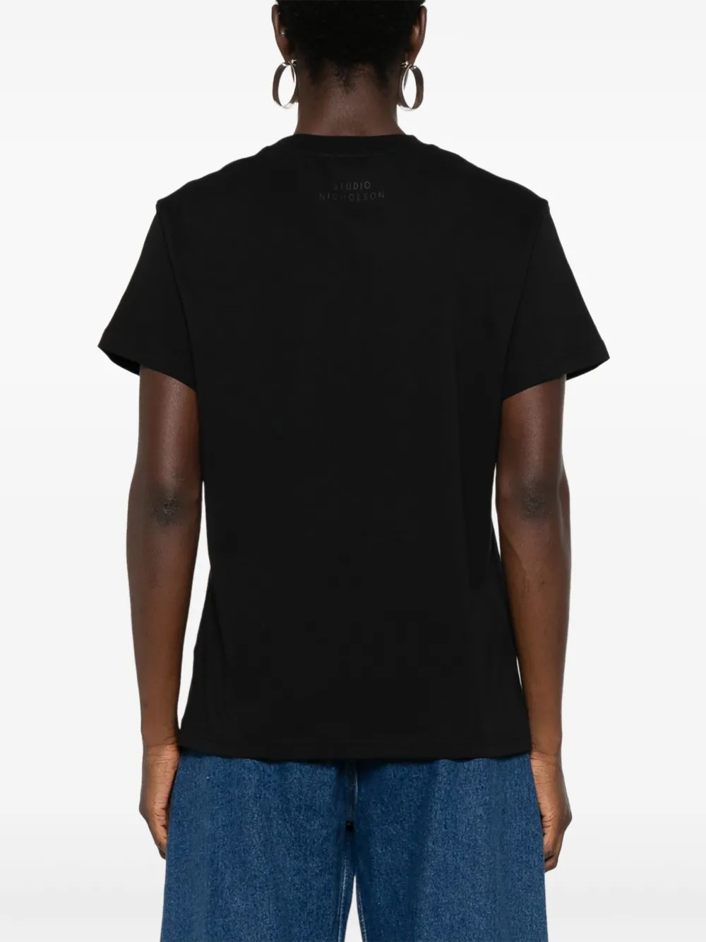Black t-shirt worn by a person, showing the shirt fit