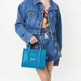 Blue bag carried by a person, showing the bag's fit