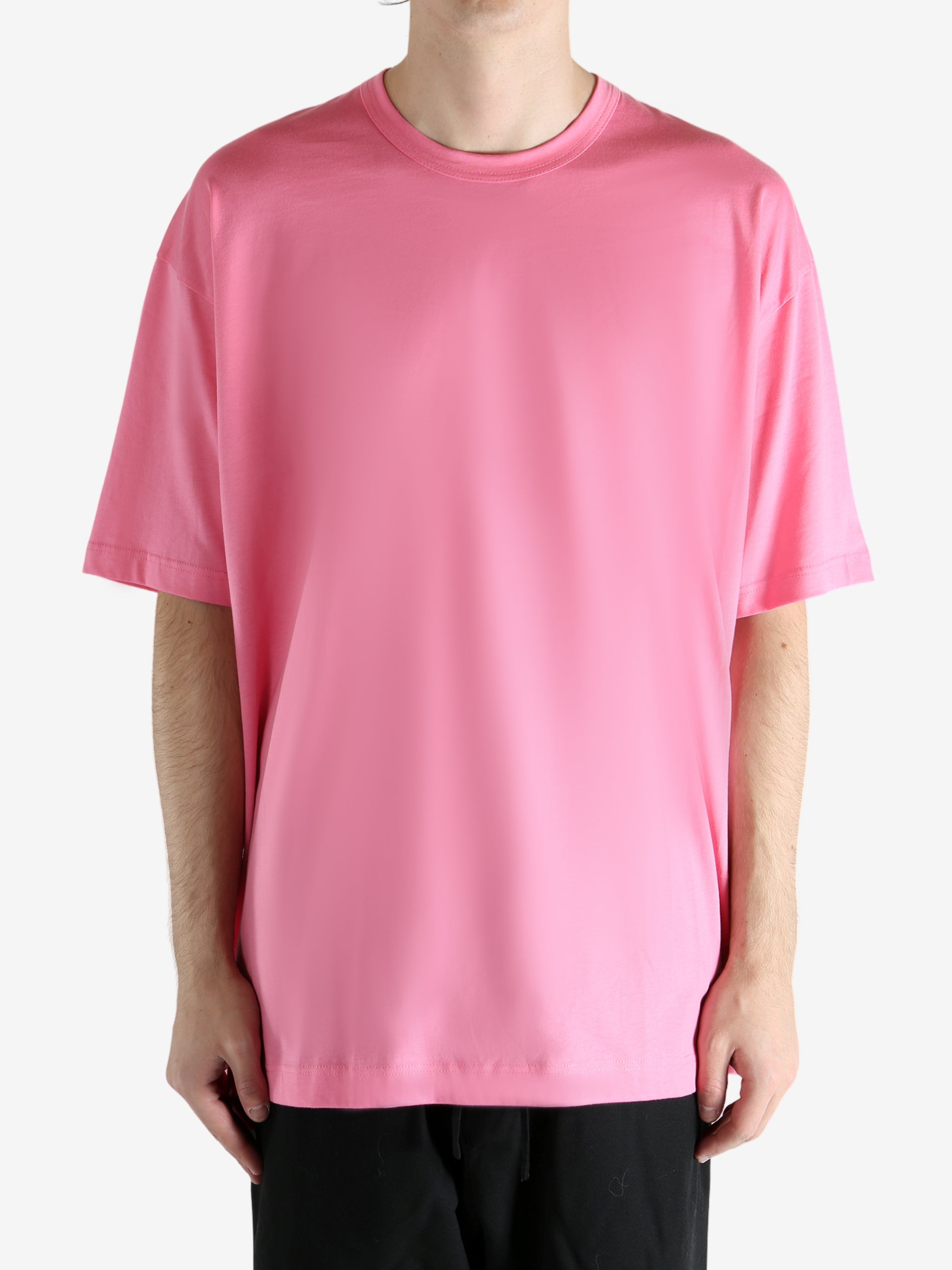 Pink t-shirt worn by a person, showing the shirt's fit