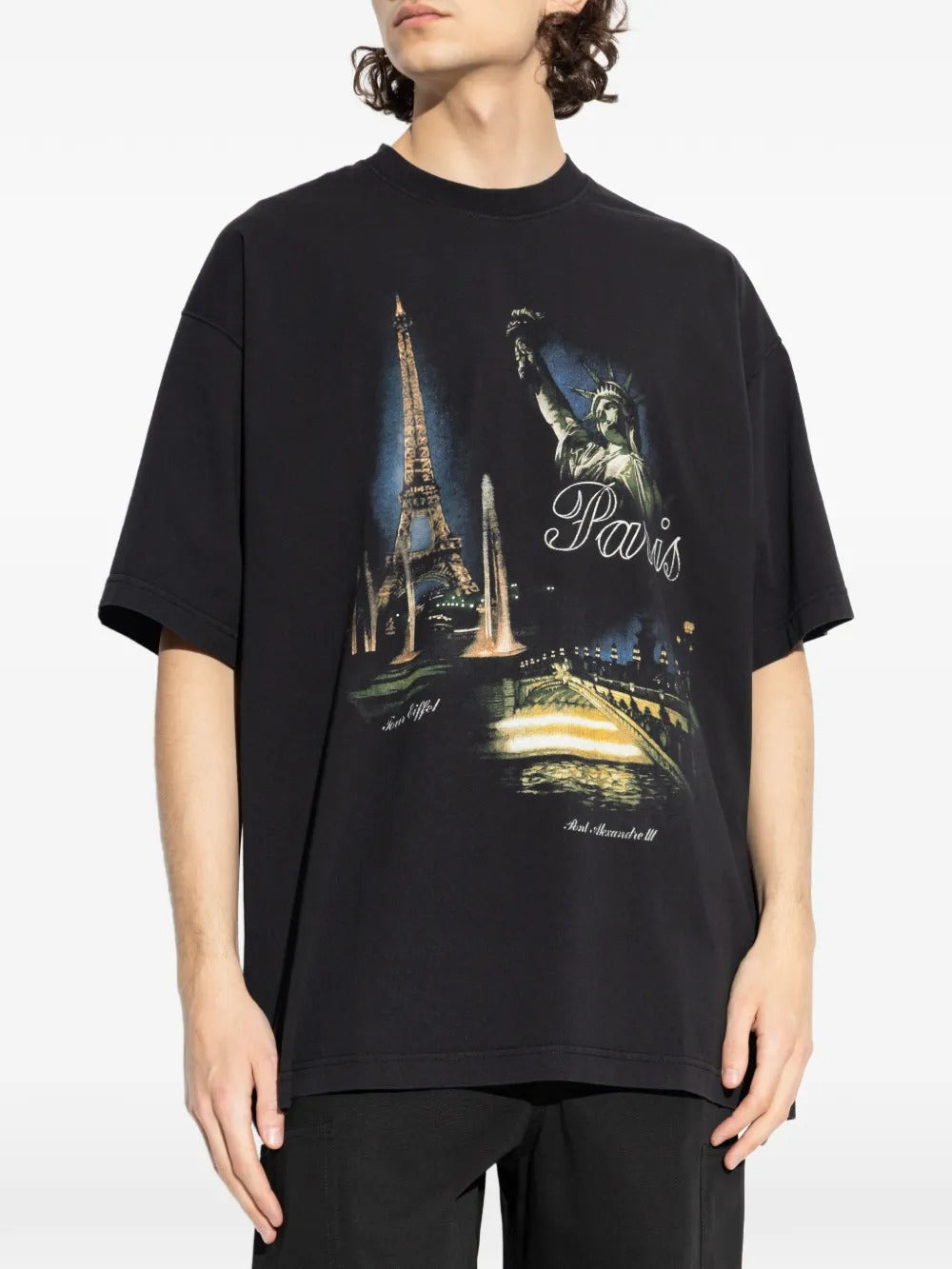 Black t-shirts worn by a person, showing the t-shirts fit