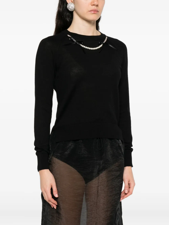 Black knitwear worn by a person, showing the knitwear's fit