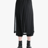 Black pants worn by a person, showing the pants fit