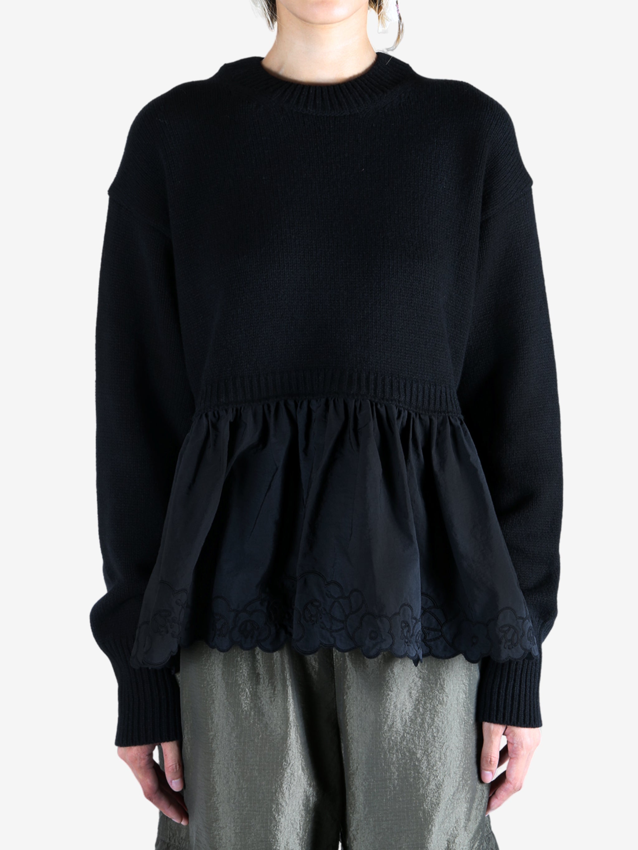 Black sweat worn by a person, showing the sweat's fit