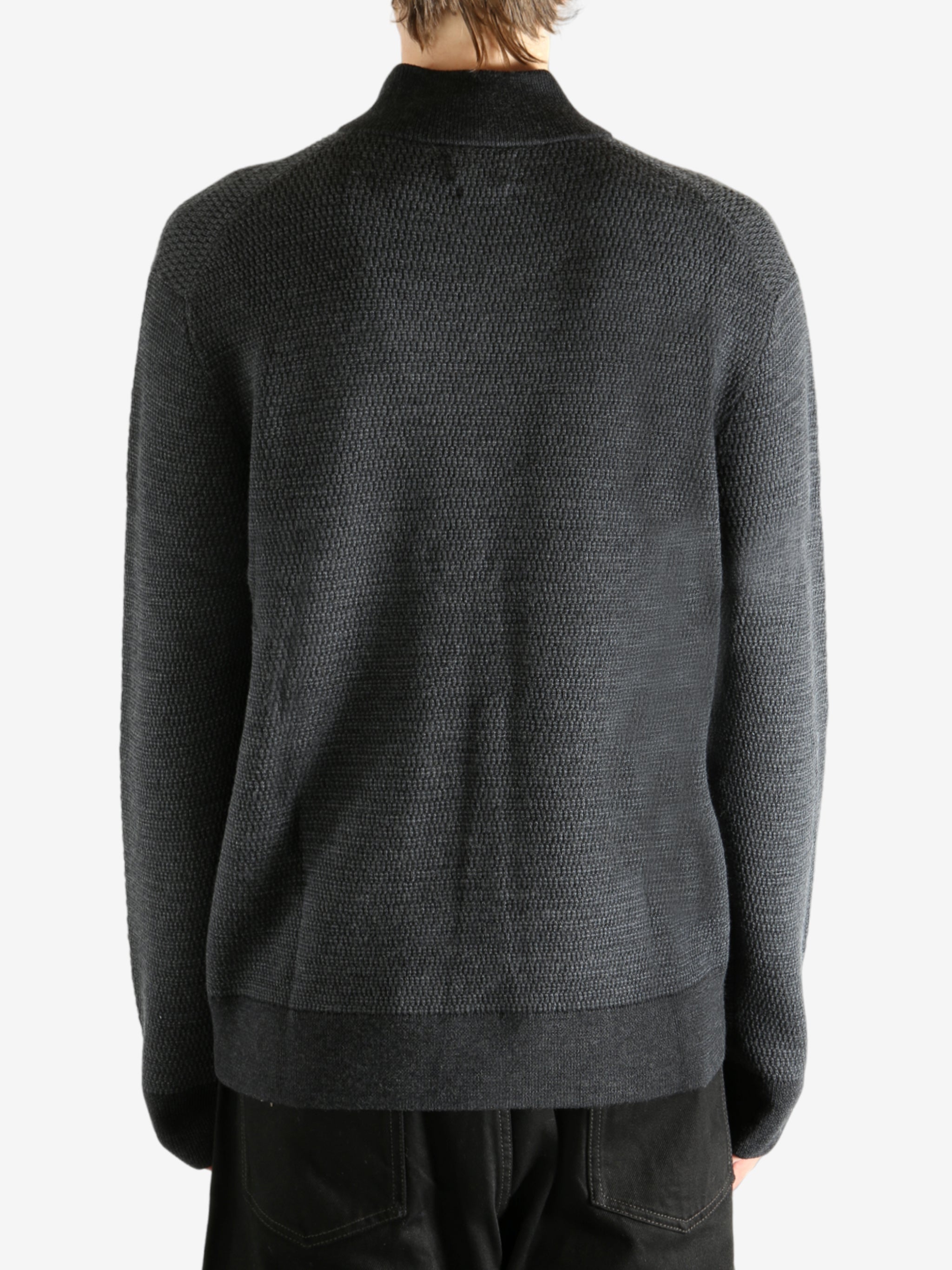 Grey knitwear worn by a person, showing the knitwear's fit