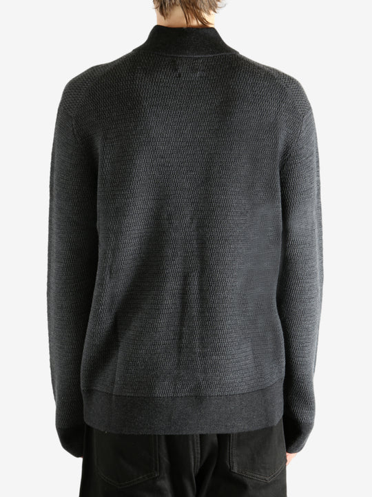 Grey knitwear worn by a person, showing the knitwear's fit