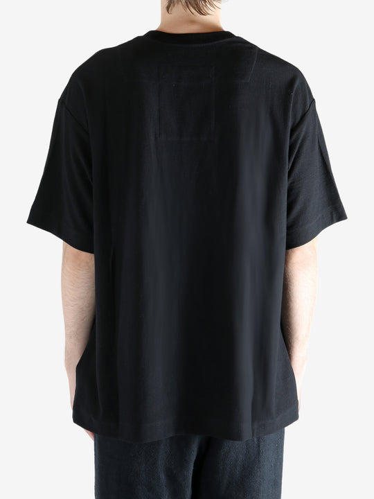 Black t-shirts worn by a person, showing the t-shirts' fit